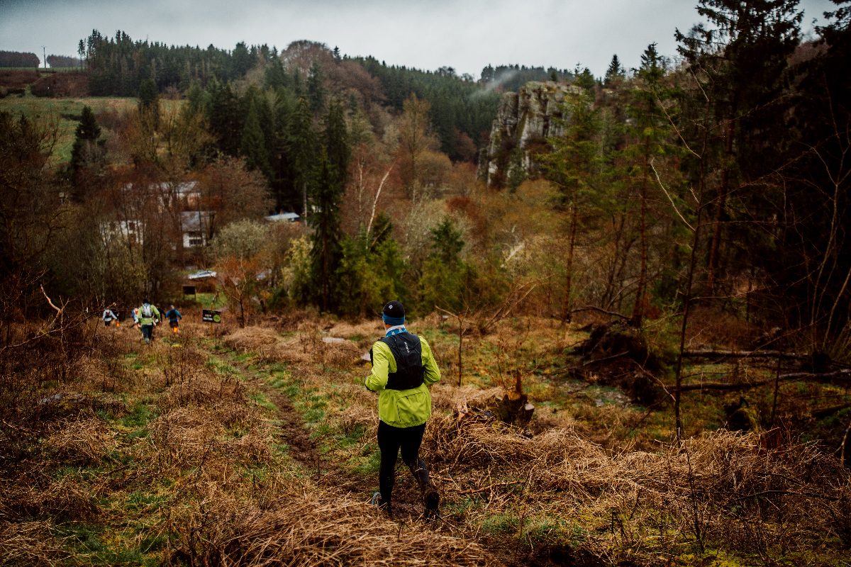 Un coureur dans les friches, les rochers en arrière-plan